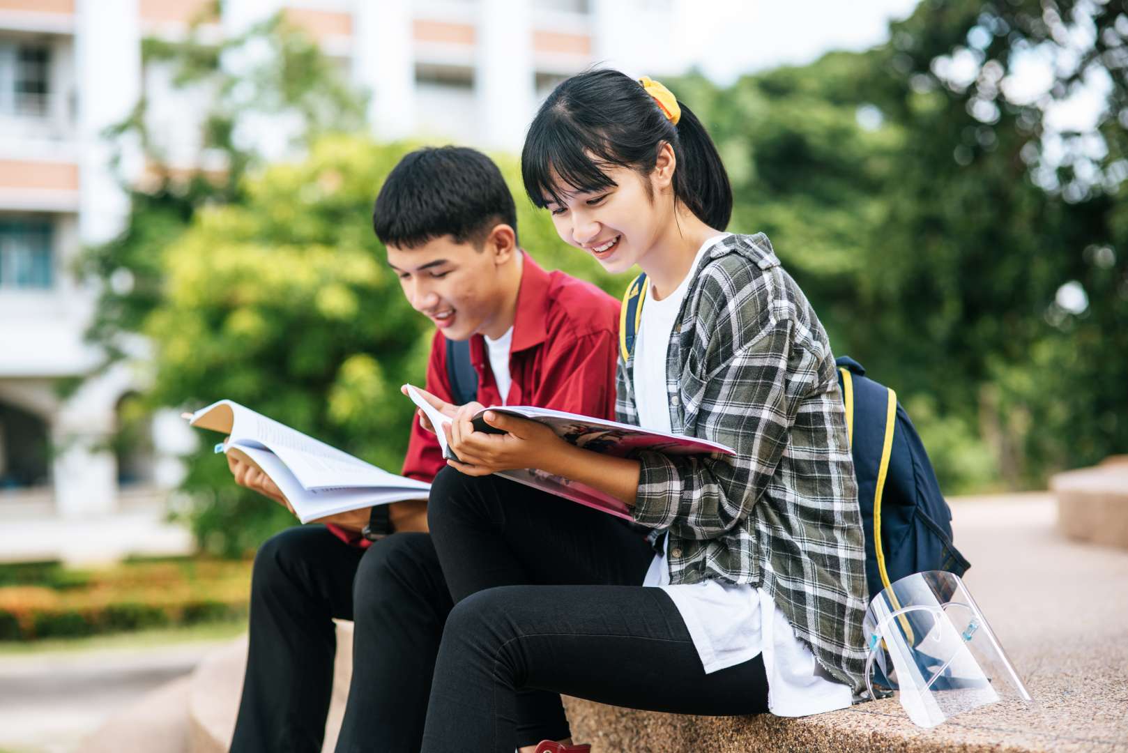 male-female-students-sitting-reading-books-stairs